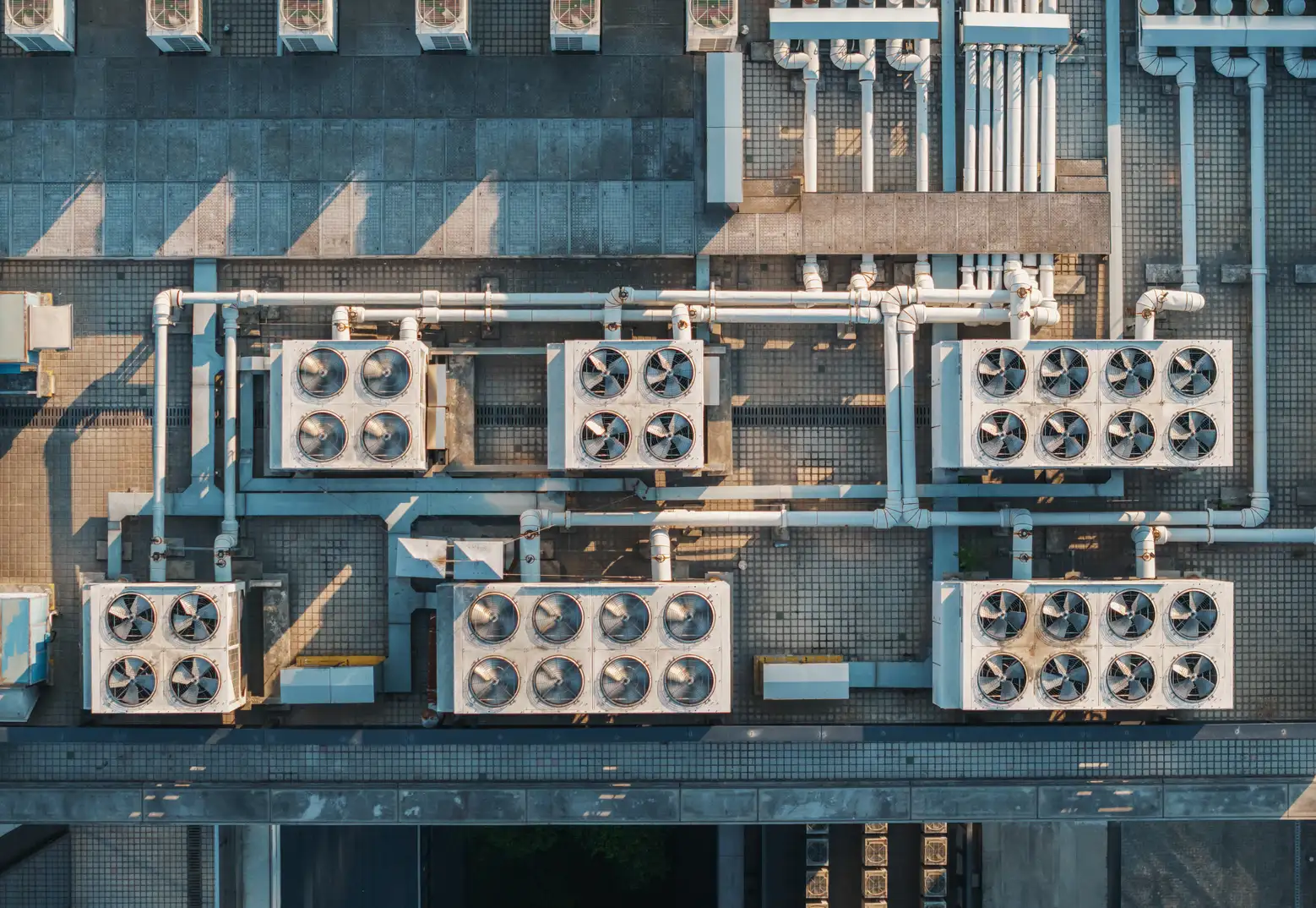 Aerial view of HVAC units and pipework on a commercial flat roof during a commercial roof inspection for an insurance appraisal